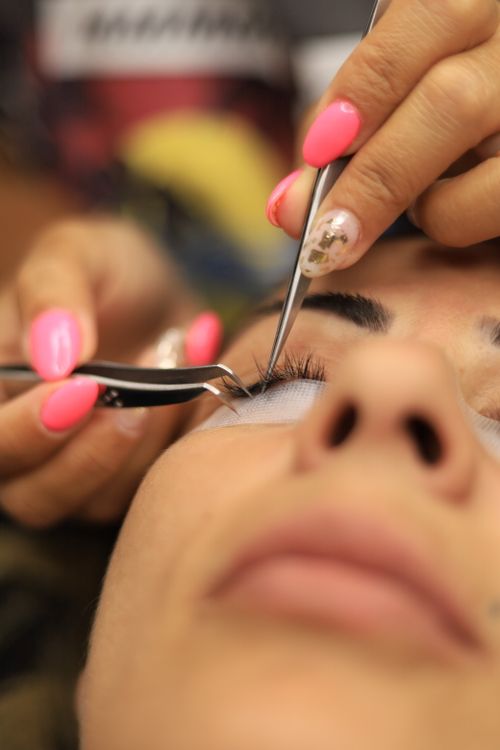 Close-up of eyelash extension application — precise lash work by a beauty therapist